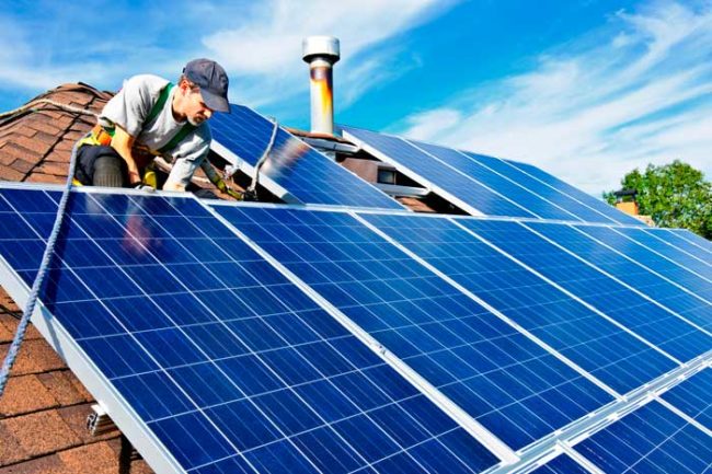 6 Green Housing Trends man-installing-solar-panels-on-a-roof