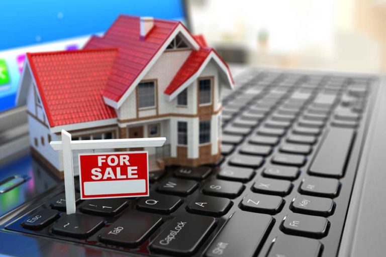 online house shopping picture of a laptop with a model house on keyboard