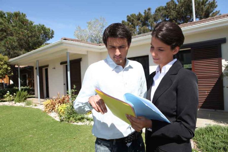 Become a successful realtor A realtor with a client in front of a hows
