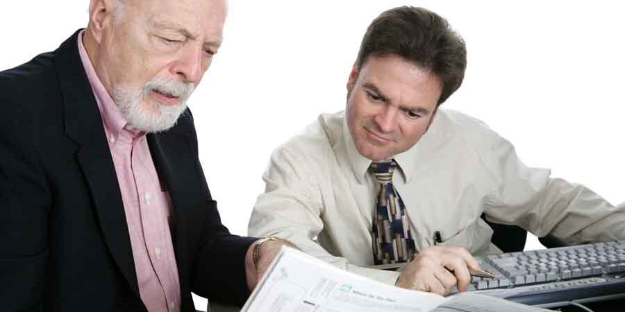 Property-Taxes Property Taxes an elderly man seems holding tax forms sitting with an accountant