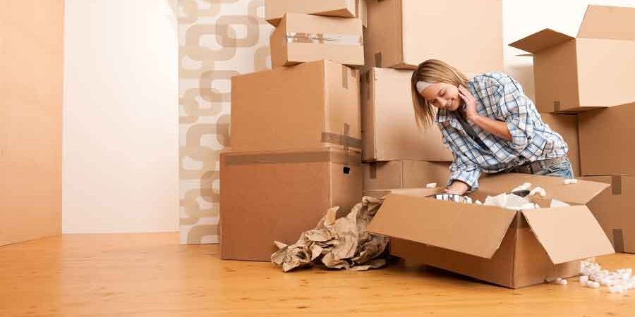 A young single homebuyer woman unpacking boxes in her new home
