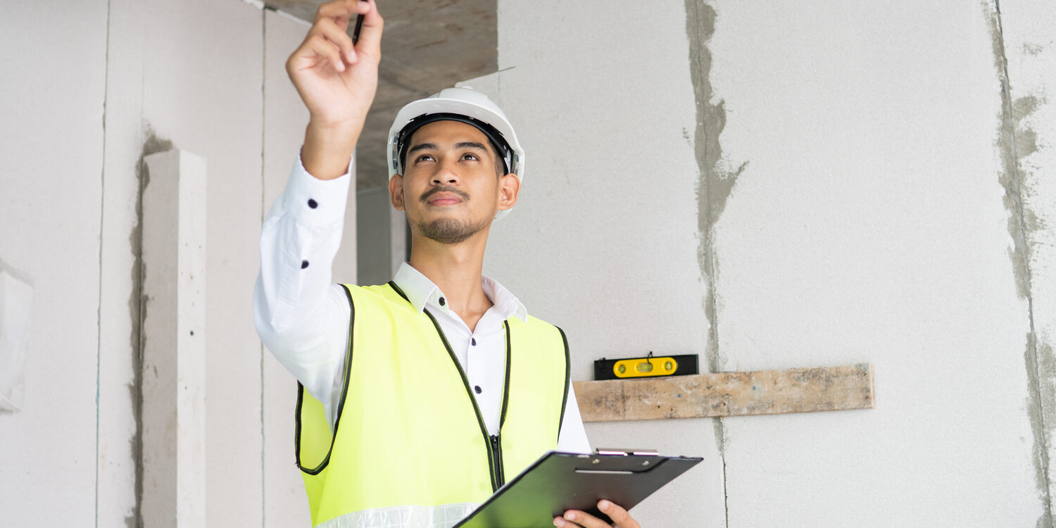 Inspector holding clipboard opening paper and checking building