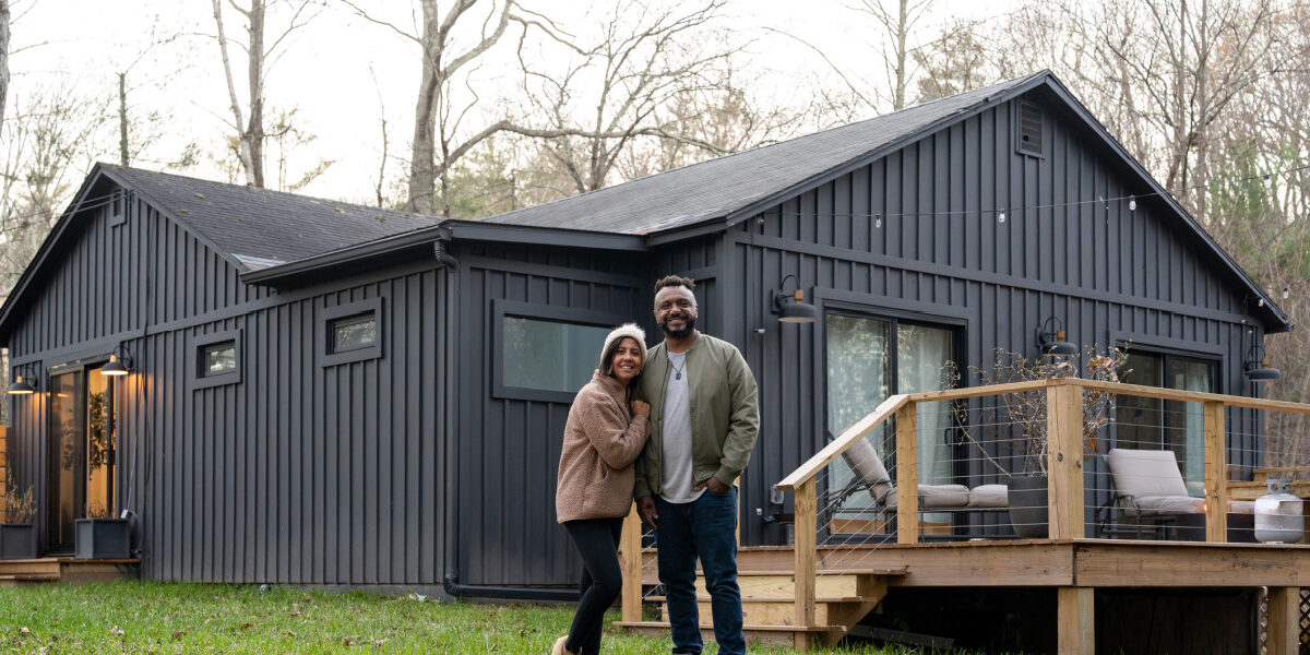 10-asheville-homebuyer-mortgage-mistakes-to-avoid First-time homebuyers in Asheville, NC standing outside their new home