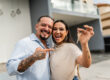 Man and woman holding keys after buying home in Asheville, NC