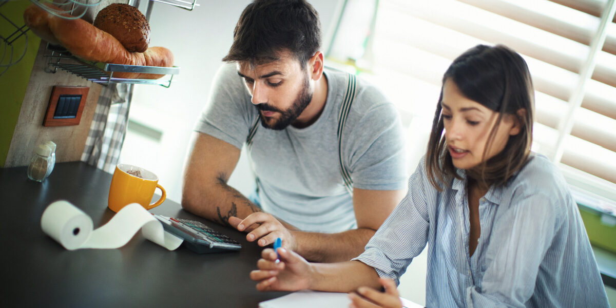 Two homeowners calculating for refinancing their home mortgage loan