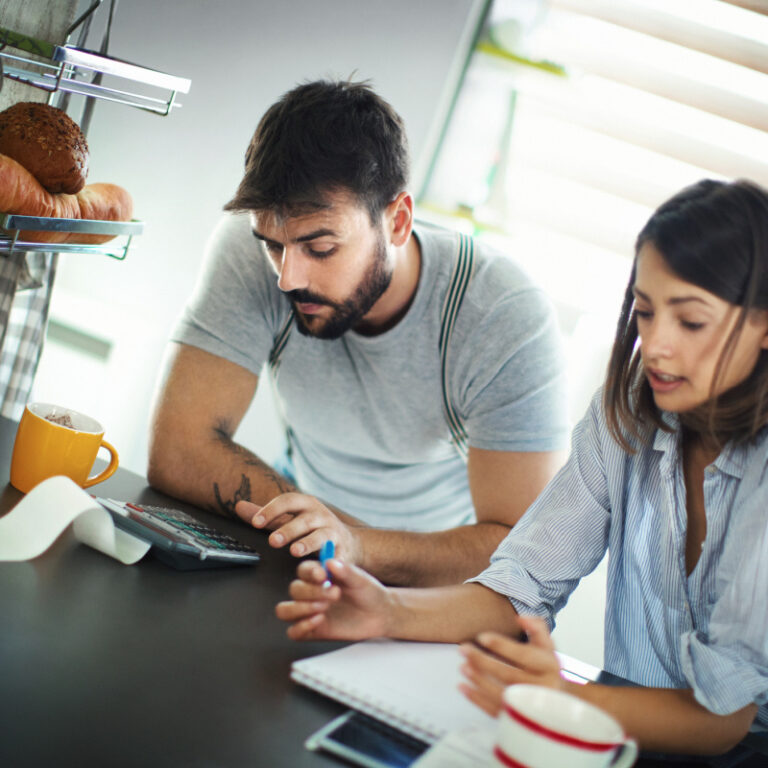 should-you-refinance-your-asheville-home-in-2026 Two homeowners calculating for refinancing their home mortgage loan