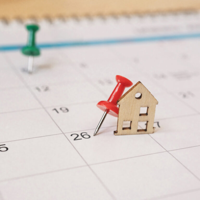 red thumbtack with miniature wooden house on white calendar Homebuying timeline calendar